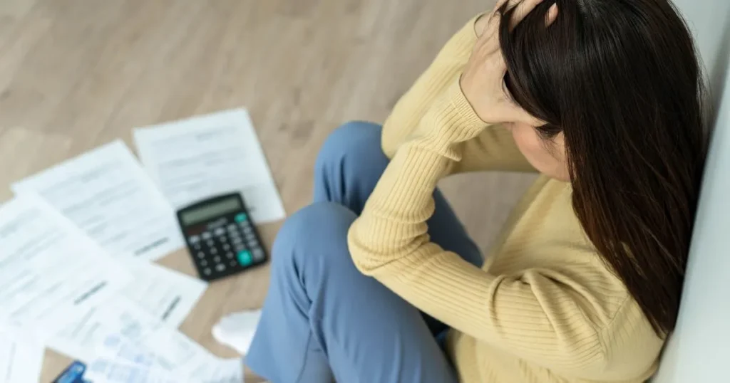 Lady in distress sitting next to her bills