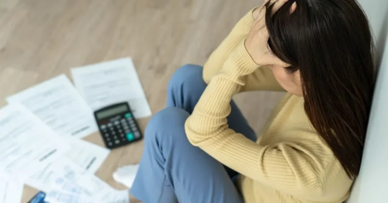 Lady in distress sitting next to her bills
