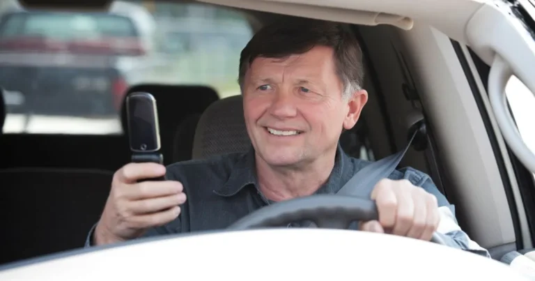 Old man distracted by his phone while driving