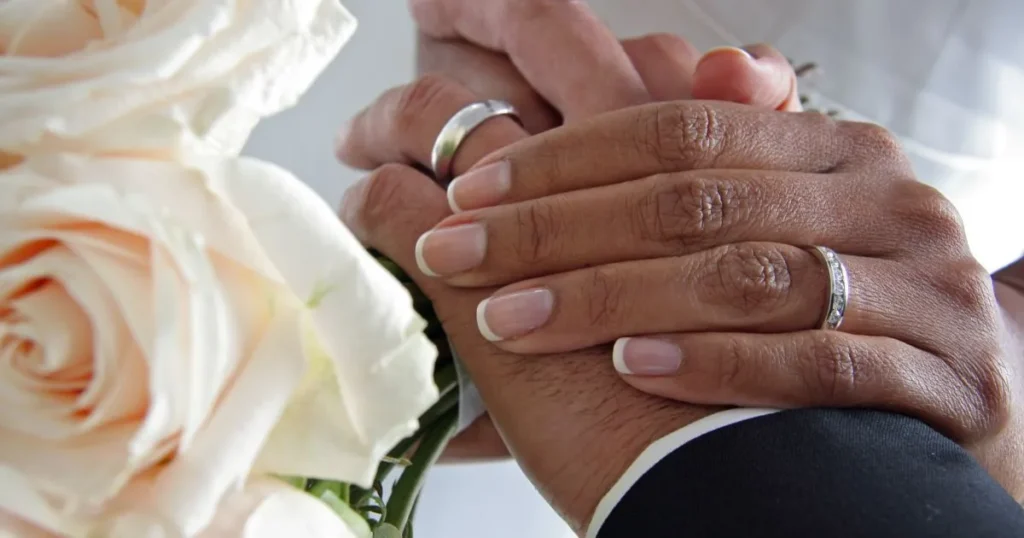 Married couple holding hands at their wedding.